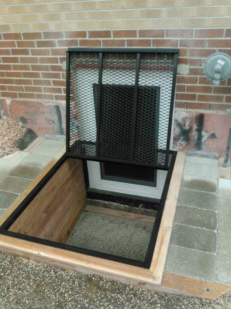 Black safety grate over a brick window well
