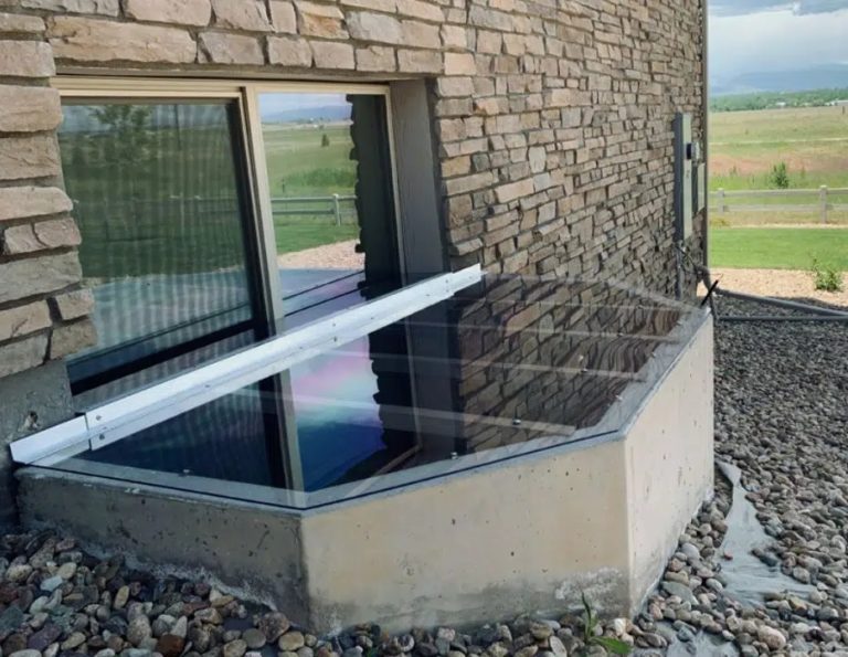 Clear lean-to window well cover against a brick home