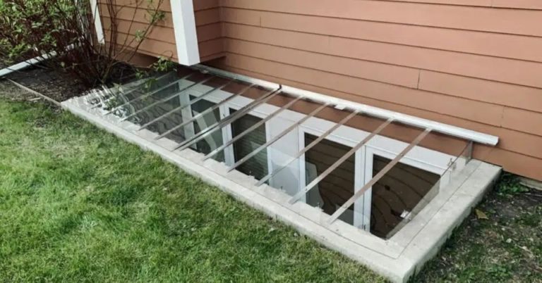 Flat clear cover over a long window well beside a lawn