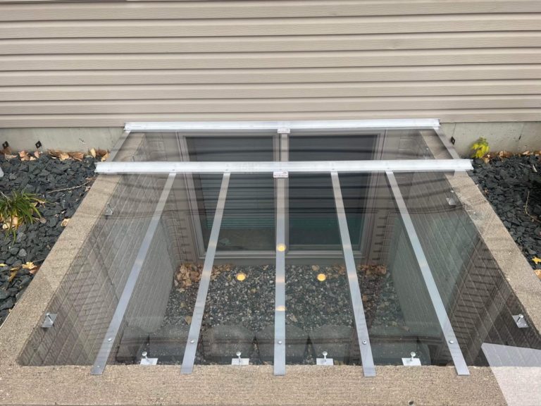 Close-up of a clear window well cover with an aluminum frame