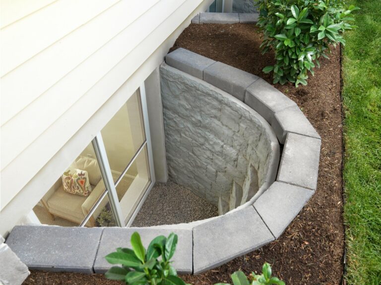 Stone-look window well with steps outside a basement slider window
