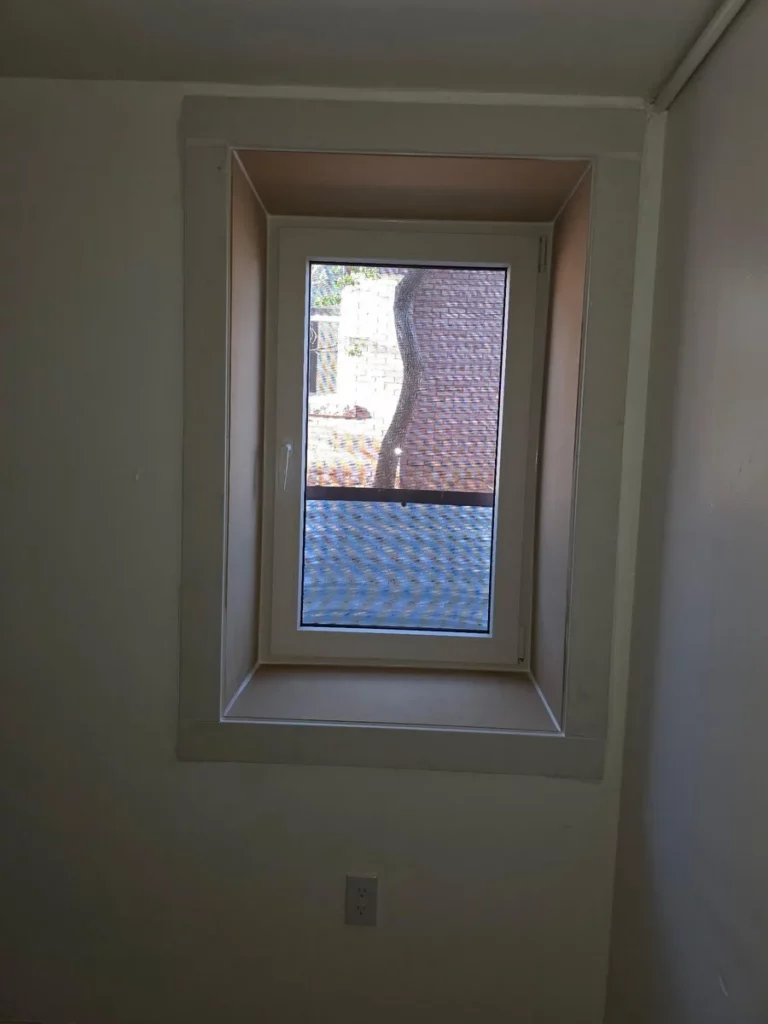 White tilt-and-turn egress window seen from inside a basement room